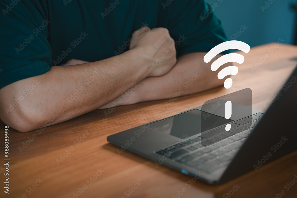 Fototapete Person sit in front of a laptop displaying a Wi-Fi error symbol, indicating internet connectivity issues. Scene conveys frustration with technology and network failures in a modern work environment.