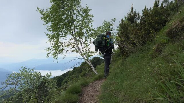 Backpacker Walking Up On Trail Of Grignetta Mountain In Lecco, Lombardy, Italy. tilt-up shot