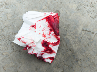 Crumpled bloody tissue paper on the ground concept murder, crime, accident, incident, emergency