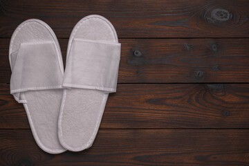 White Spa Slippers on Dark Wooden Background for Relaxation and Hospitality Concepts