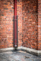 Roof drain pipe. Red brick wall, historical building
