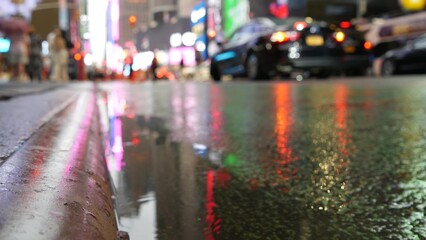 New York City Times Square, Manhattan Midtown Broadway street, USA. Wet american urban road, autumn rainy day, traffic defocused. People pedestrians. Advertising signs, commercial billboard screens.