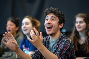 Obraz premium Engaged participants in drama workshop express excitement and joy while performing. Their animated expressions reflect creativity and collaboration in vibrant learning environment