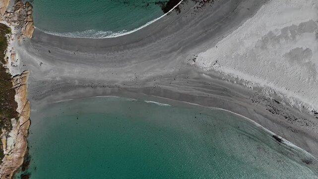 Tourists walking across sandbar of Diamond Island towards beach, aerial top down view