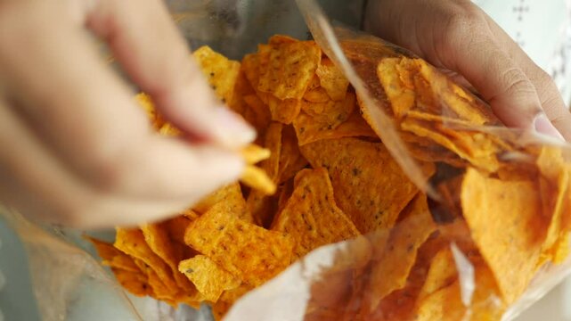 holding a open potato chips packet 