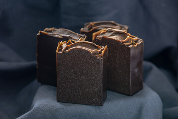 Pieces of craft natural tarry soap on a black fabric background