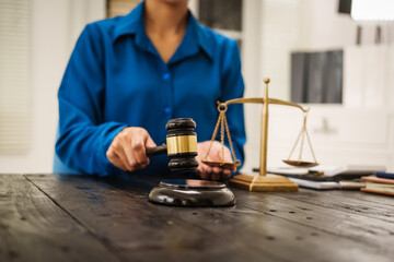 An Asian female lawyer sits at her desk in the office,working on legal documents with computer,providing online legal consulting,reviewing contracts,drafting wills,offering signature certification