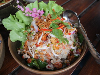 Spicy fresh vermicelli salad mixed with dried shrimp, shallot and peanut serving on the plate. Famous local food in Thai restaurant. 
