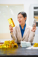 An Asian businesswoman is sitting at her desk, discussing gold bars, deposits,and the gold market...