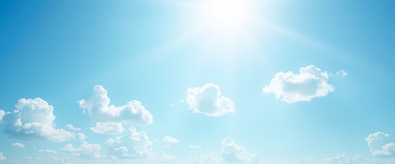 Bright blue sky with white clouds and sun shining through