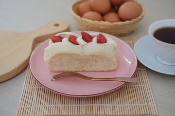 Strawberry cheese cake with tea on a table.
