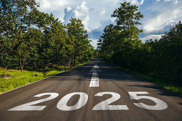 Road to new year 2025 has written on the road in the middle of asphalt road, Planning of new year to achieve net zero and carbon emission reduction concept.