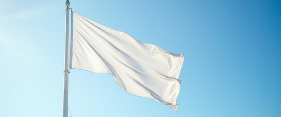 Blank white flag waving in the wind against a blue sky