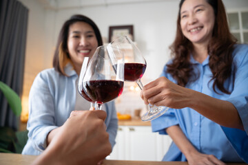 Senior middle aged Women Asian friends talking and holding wine glasses and smile take a selfie in kitchen. Reunion friendship greeting concept