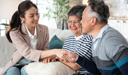 Asian senior couple listens handshake accept to a health insurance broker's advice at home. Discuss...