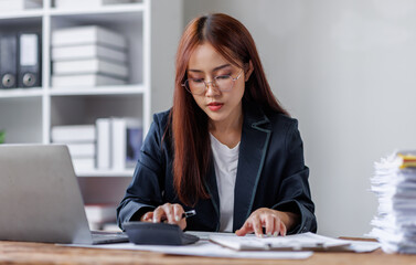 Business financing accounting banking concept. Business woman hand doing finances and calculate on desk about cost at home office. Woman working on desk with using calculator, finance accounting.
