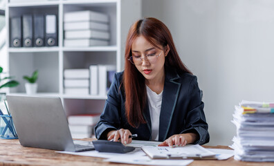 Business financing accounting banking concept. Business woman hand doing finances and calculate on desk about cost at home office. Woman working on desk with using calculator, finance accounting.
