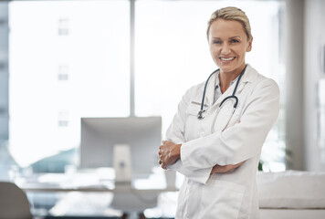 Doctor, confident and portrait in hospital for healthcare, career path and smile in office space. Mature woman, cardiologist and arms crossed in clinic for friendly service, positivity and trust