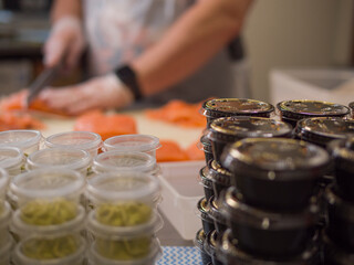 Gloved hands work with precision as the chef slices fresh salmon into smooth, even portions. His special knife moves effortlessly through the salmon, creating perfect, evenly cut salmon slices.