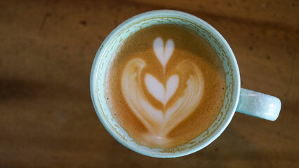 Top view latte art coffee on wood background