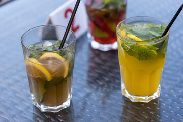 Two glasses of drinks with a lemon slice in the middle