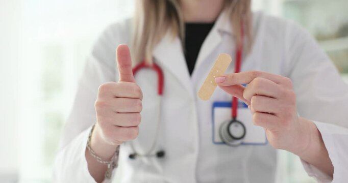 Doctor holding a patch and showing thumbs up in clinic