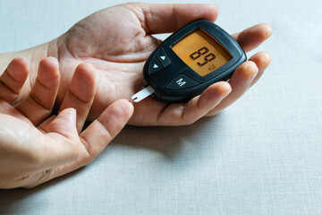 hand of people check diabetes and high blood glucose monitor with digital pressure gauge. Healthcare and Medical concept	