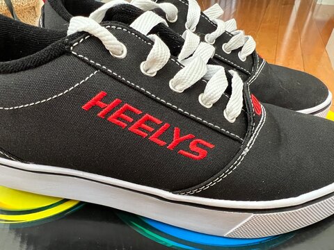 Black and white pair of Heely's brand rolling shoes.