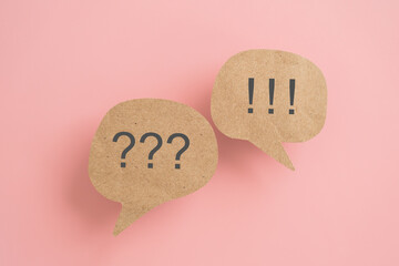 question and answer or communication, customer support or feedback, FAQ concept , grunge brown real speech bubbles paper cut with question and exclamation marks on pink background