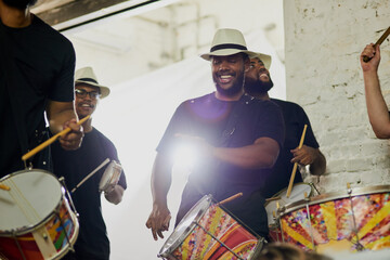 Happy, music and men at carnival with drums for festival, cultural celebration and party event. Musician group, concert and people with musical instrument for rhythm, sound and tune for performance