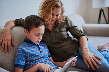 Mother, son and sofa with tablet for elearning, ebook or online research together at home. Young, mom and child or kid with technology for browsing, scrolling or learning app for education at house