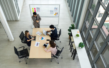 Group of business people are gathered in a meeting room, discussing and sharing ideas around a...