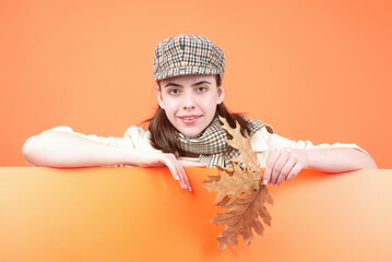 Studio portrait of young woman with autumn fall leaves.