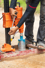 Workers are coring to check the thickness and quality of pavement-recycling road construction work.