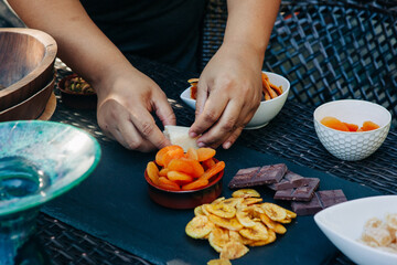 African American woman arranges food on a cutting board