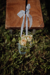 Country wedding decor with roses, lace ribbon, and camomile in a jar.