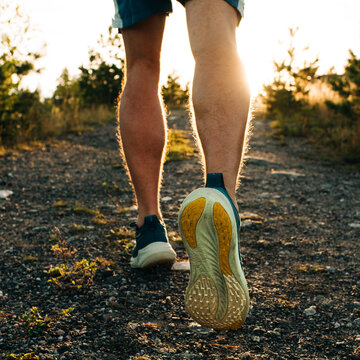 mans legs ready to go for a run up a hill at sunset