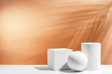 White geometric shapes arranged stylishly on a soft peach background in a minimalist setting