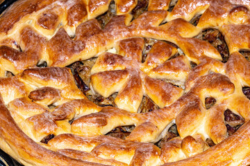 Decorative meat pie with a tasty crust with hearty minced beef cooked with vegetables. Homemade tasty meat pie close up photo.
