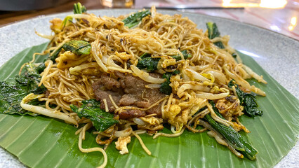 Fried Misoa or misua goreng Fried misoa on a white plate and covered with banana leaves.