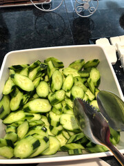 Sliced ​​cucumbers in a plate on the buffet table.