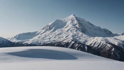 Obraz premium Isolated snow-covered mountain peak under a clear blue sky in a serene winter landscape