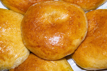 Close-up food photography of baked yeast dough buns in a round shape.