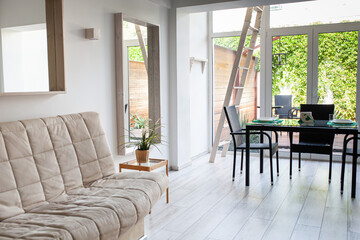 Stylish modern interior of duplex apartment with courtyard, eco friendly apartment with wooden floor and furniture. Minimalistic interior. Selective focus.