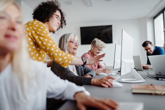 Portrait of female senior students learning how to work with digital technology. Elderly people attending computer and technology education class. Digital literacy.