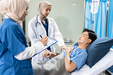Fototapeta premium healthcare and people concept - doctor talking to male patient at bed in hospital.