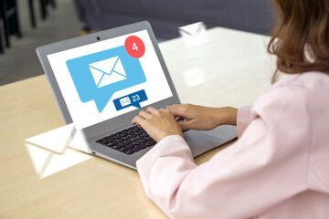 Fototapeta premium Businesswoman hand typing on laptop computer keyboard, surfing internet on office table with email icon, email marketing concept, send e-mail or news letter, online working internet network.