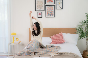 A beautiful woman wakes up in her bed. Her dress looks soft and comfortable.