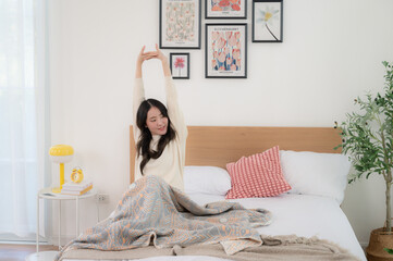 A beautiful woman wakes up in her bed. Her dress looks soft and comfortable.