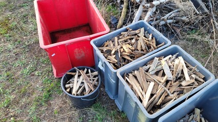 Ensemble de caisses grises, rouges et un sceau, de petit bois sec pour l'hiver